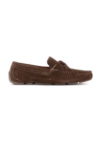 Mocasines de ante marrón con detalle de costura, un acento de lazo y una suela de goma baja, que presentan una punta redondeada y un diseño flexible.