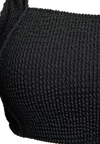 Zwarte smocktop van stof met een gestructureerd oppervlak met een golvend patroon en verstelbare bandjes. Close-up weergave die de details benadrukt.
