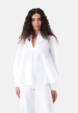 Camicia bianca con scollatura a V, maniche lunghe a sbuffo e vestibilità comoda. Tessuto liscio con una texture netta, senza motivi o accenti visibili.