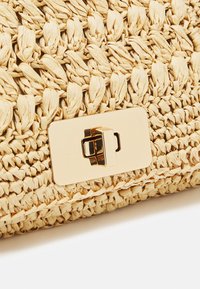 Borsa a mano intrecciata in paglia di colore beige naturale, con una chiusura rettangolare dorata e una finitura testurizzata con motivi intrecciati distintivi.