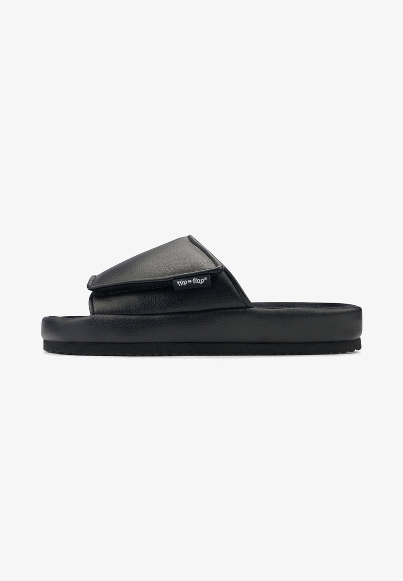 Black slide sandals with a padded upper and a textured sole, featuring a flap design and a small brand logo tag on the side.