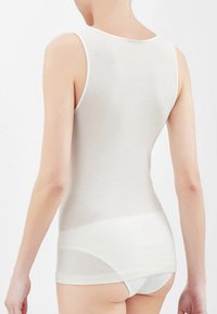 Canottiera bianca senza maniche con una texture liscia e costata. Presenta un colletto rotondo e un design aderente, che si estende sotto la vita.