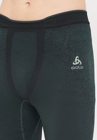 Odlo herre aktive tights i mørk teal, med en glatt tekstur, en tettsittende design og et logoelement, samt en kontrastfarge i svart på midjebåndet.