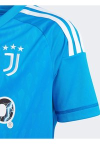 Blå idrottströja med rund halsringning, korta ärmar och tre vita axelränder. Broderad logotyp och texturerat mönster på tyget.