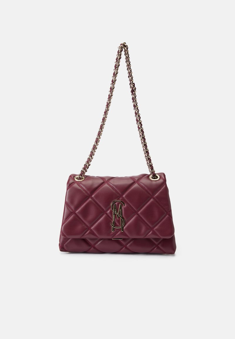Sac à main en simili cuir matelassé bordeaux, avec un ornement de logo doré et une bandoulière en chaîne métallique. Forme rectangulaire avec une surface texturée.