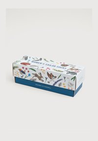 Scatola per calzini da marinaia da donna con un esterno bianco decorato con illustrazioni colorate di animali e fiori, e una base blu. Il testo recita "DESIGNATO IN CORNWALL."