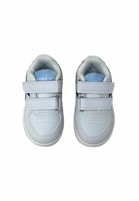 Weiße Kindersneaker mit zwei Klettverschlüssen, glattem Synthetikmaterial, durchlöchertem Zehenbereich und gepolstertem Mesh-Futter.