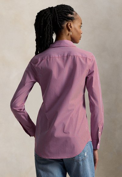 Chemise à rayures rouges et blanches avec manches longues, poignets à boutons et col pointu, dotée d'un ourlet incurvé et d'une texture de tissu lisse.