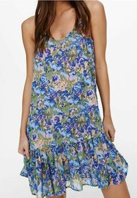 Blumenmusterkleid mit blauen, lila und grünen Farbtönen, einem V-Ausschnitt und einem fransigen Saum. Hergestellt aus leichtem, fließendem Stoff.