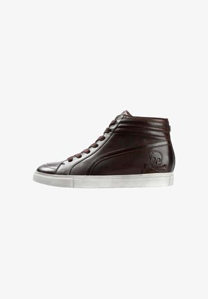 Zapatillas altas de cuero marrón con suela de goma blanca, paneles laterales texturizados y un emblema de calavera y huesos cruzados en el tobillo exterior.