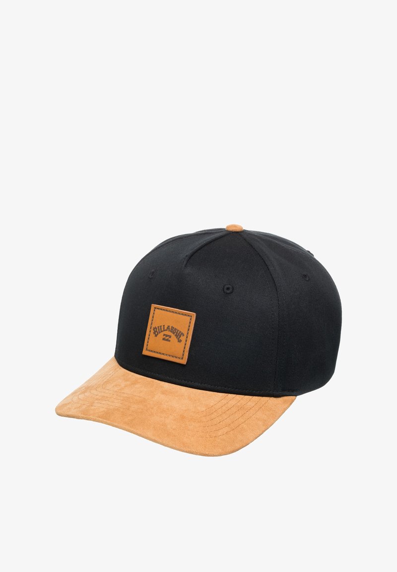 Black cap with a tan suede brim, featuring a square brown leather patch with the brand name. Structured design, accented stitching.
