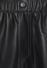Schwarze Jogginghose aus Kunstleder mit einem gerafften Bund und einem Druckknopfverschluss sowie einer Seiten Tasche, die eine glatte Textur und einen glänzenden Look aufweist.