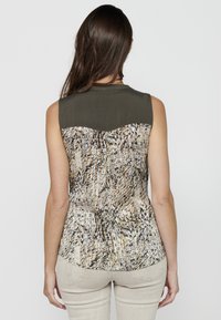 Top senza maniche con parte superiore verde oliva e sezione inferiore a motivo in tessuto beige, nero e marrone. Orlo arrotondato.