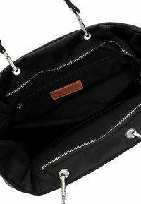 Black handbag interior with two zippered compartments and silver-tone hardware, showing fabric lining and leather brand label.