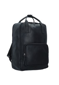 Mochila de cuero negro con correas desmontables, bolsillo delantero con cremallera y textura suave. Presenta un asa en la parte superior y acentos cosidos.