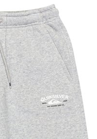 Grijze sweatpants van zacht materiaal, met een elastische tailleband en een trekkoord, zijzakken en een witte logoprint.