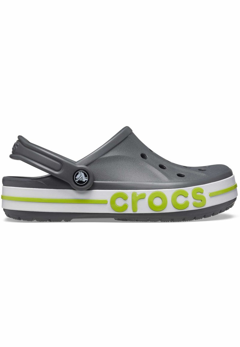 Szare Crocs z białą i zieloną paskowaną podeszwą, z otworami wentylacyjnymi, tylnym paskiem i zielonym logo "crocs" po boku.