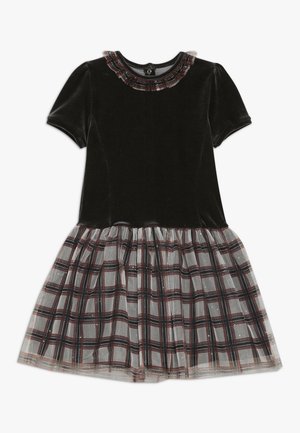 Czarna aksamitna sukienka z krótkimi bufkami, z plisowaną spódnicą z tiulu w kratę w szarościach, czerwieni i czerni. Ozdobiona falbanką przy dekolcie, zapinana na guziki z tyłu.