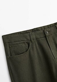 Oliivinvihreät housut, joissa on sileä pinta, napillinen suljin, vyölenkit ja vasemmalla puolella oleva etutasku.