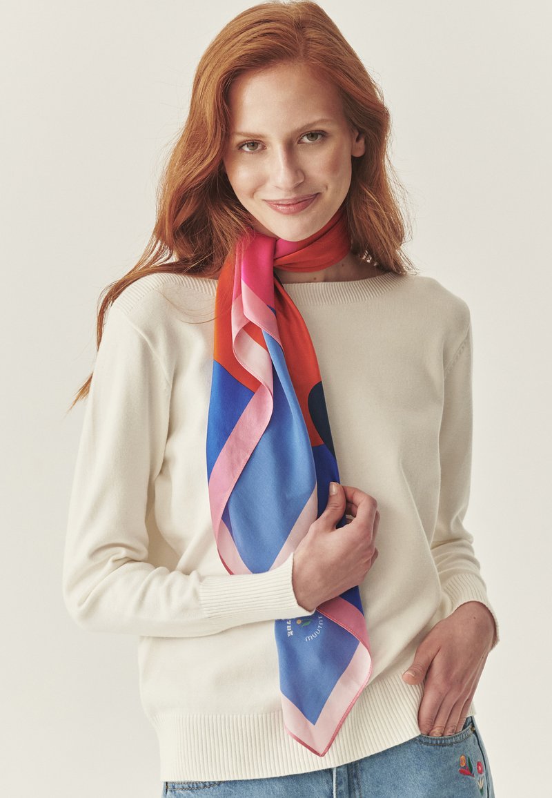 Sciarpa di seta con motivo geometrico in colori vivaci come rosso, blu, rosa e arancione. Tessuto liscio con bordo a contrasto.