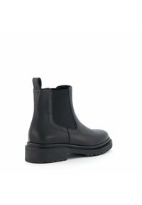 Bottes Chelsea en cuir noir avec des panneaux élastiques sur les côtés, une tige haute et une semelle en caoutchouc texturée, dotées d'une languette à l'arrière.
