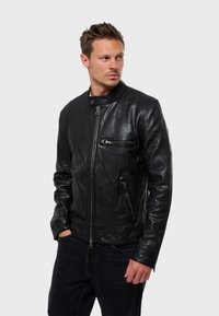 Černá kožená bunda se zipovým zapínáním, stojáčkovým límečkem a dvěma zipovými kapsami. Měkká textura a přiléhavý design.