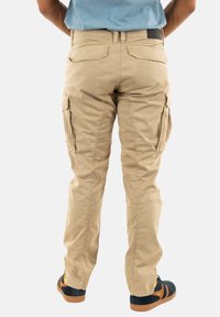 Beige cargobroek met een ontspannen pasvorm, voorzien van meerdere zijzakken, versterkte knieën en een gladde, duurzame katoenmix.