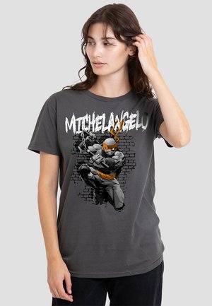 Gray cotton t-shirt featuring a printed graphic of a cartoon character with orange accents, set against a brick wall design.