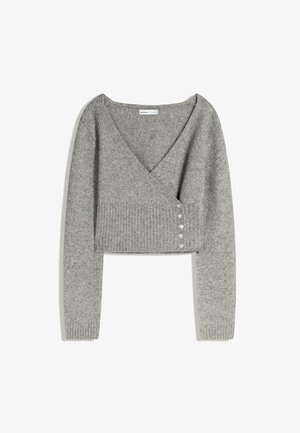 Grå kort sweater lavet af blødt stof, med lange ærmer, en dyb V-hals og fem små knapper på venstre side. Ribbede detaljer ved kanten.
