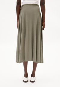 Olive green, knee-length skirt made of soft fabric; features a wide waistband and a flowing design with pleats for movement.