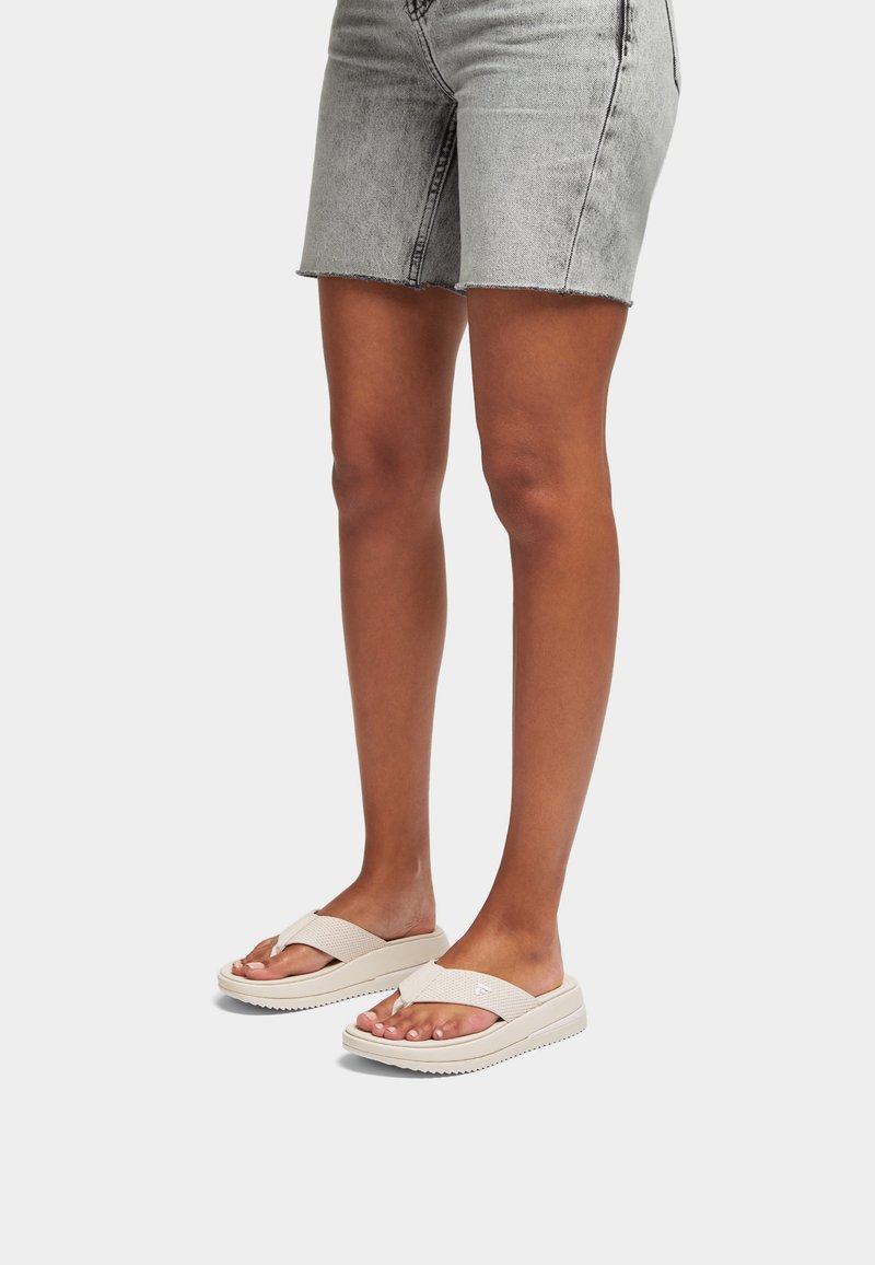 Beige teenslippers met een gestructureerde bovenste band, platte zool en geprinte details. Ideaal voor casual gebruik.