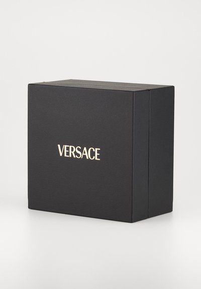 Black rectangular box made of textured material, featuring gold embossed "VERSACE" logo on the front. Closed lid design.