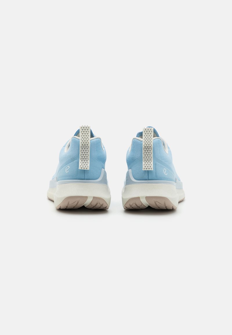 Blaue Sportschuhe verfügen über ein strukturiertes Textil-Obermaterial, eine kontrastierende weiße Sohle und Zuglaschen an der Rückseite für ein einfaches Anziehen.