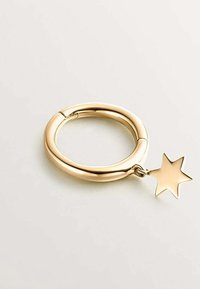 Llaveros de metal en tono dorado con un diseño circular y suave, y un charm en forma de estrella adjunto. La superficie tiene un acabado pulido.