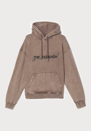 Brauner Kapuzenpullover aus weichem Baumwollmix, mit einer Fronttasche und grafischem Textdesign. Lockerer Schnitt mit gerippten Bündchen und Saum.