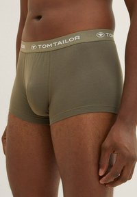 Olive green boxer shorts with a soft texture, elastic waistband featuring "TOM TAILOR" logo. Close-fitting design, minimal seams.