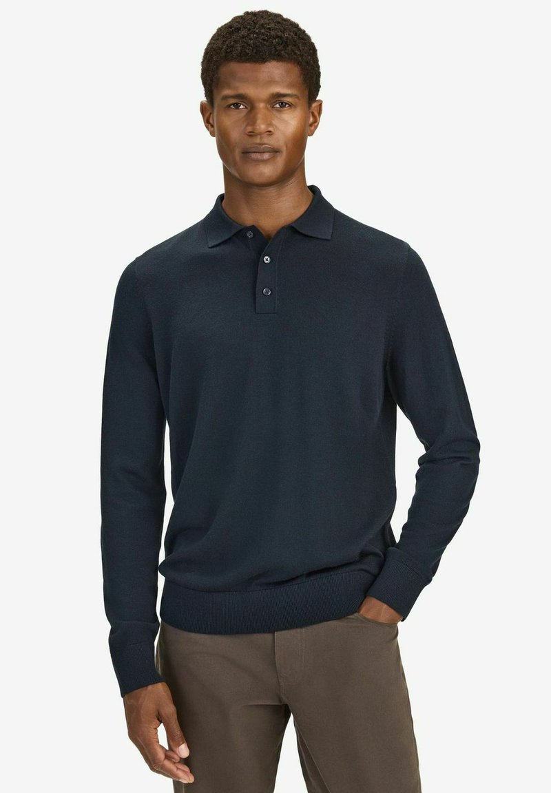 Tummansininen pitkähihainen polo-paita, jossa on kaulus, kaksi nappia, ribbireunat hihoissa ja istuva alahelma. Pehmeä neulottu materiaali.