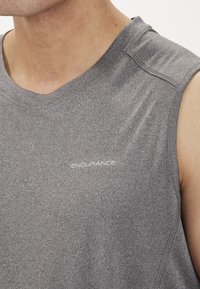 Grå ærmeløs træningsskjorte lavet af struktureret materiale, med et lille hvidt "ENDURANCE" logo på forsiden og minimale syninger.