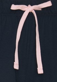 Marineblaue Sweatshorts aus weichem Stoff mit einem hellrosa Baumwollzugband, ausgestattet mit einem gesteppten Taillenbund.