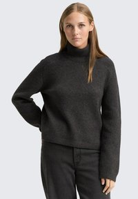 Dunkelgrauer Rollkragenpullover aus strukturiertem Strickstoff mit breiten Rippbündchen und Schulternähten. Verkürzte Passform mit einer entspannten Silhouette.