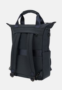 Zaino blu navy realizzato in tessuto resistente con apertura a rotolo, spallacci imbottiti regolabili e tasca laterale in rete per accessori.