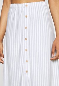Buttoned A-line skirt in light blue and white stripes; elastic waistband; wooden buttons down the front; lightweight fabric with soft texture.