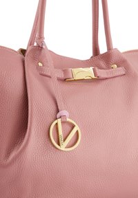 Rosa Lederhandtasche mit genoppter Struktur, goldfarbener Hardware-Verschluss und einem Logo-Anhänger. Verfügt über zwei Henkel und einen Reißverschluss.