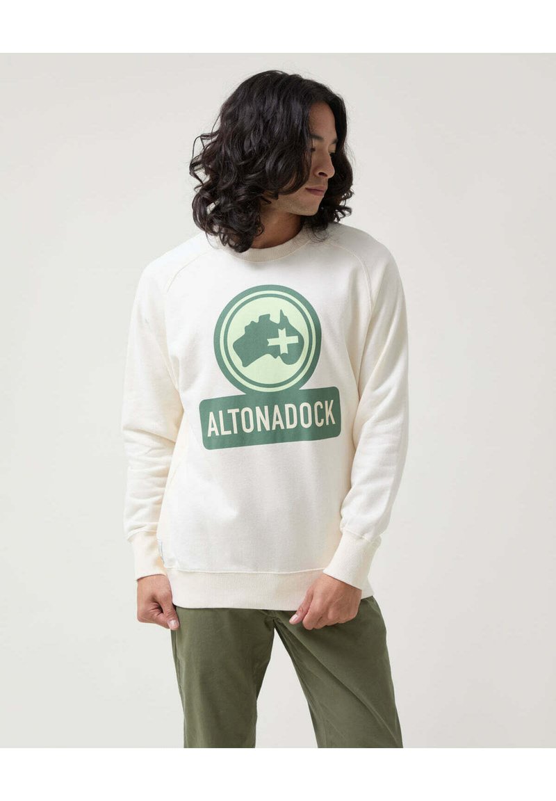Sudadera color crema de algodón, con un gran gráfico verde de Australia con una cruz y el texto "ALTONADOCK". Puños ajustados.
