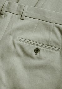 Light green trousers featuring a smooth texture, belt loops, and a back welt pocket with a matching button detail.
