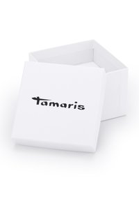 Weiße Pappschachtel mit einem flachen Deckel, auf der Vorderseite in schwarzer Schrift den Markennamen "Tamaris". Glatte Oberfläche, einfaches Design.