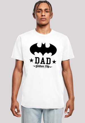 White short-sleeve t-shirt featuring a black Batman logo and "DAD Gotham City" text in bold, with stars on either side. Cotton material.