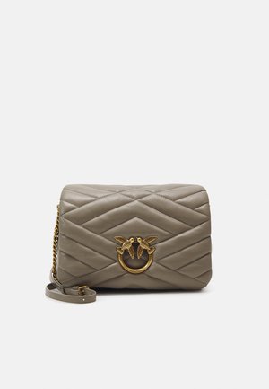Grå quiltet læder crossbody taske med guldkæde og dekorativt guldlås med to fugle, der vender mod hinanden.