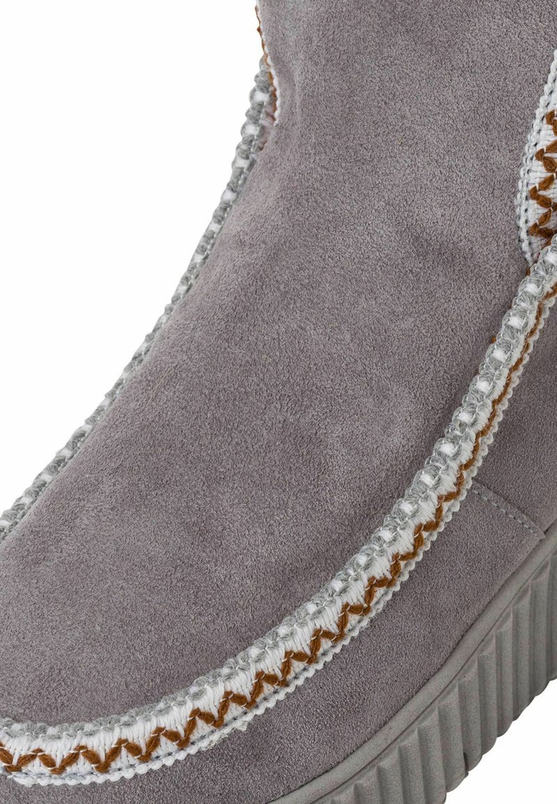 Graue Wildlederstiefel mit einer strukturierten Oberfläche, ausgestattet mit kontrastierenden braunen Nähten und einer Gummisohle mit Rillen für besseren Halt.