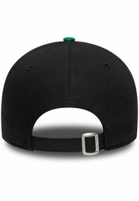 Cappello nero con visiera piatta, dotato di un bottone verde sulla parte superiore e di una chiusura regolabile sul retro con una fibbia metallica. Tessuto testurizzato.
